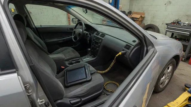Diagnostic scan tool displaying P1574 beside a parked vehicle’s dashboard