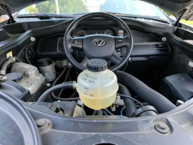 Brake fluid reservoir with visible MIN and MAX marks and its cap secured in an engine bay