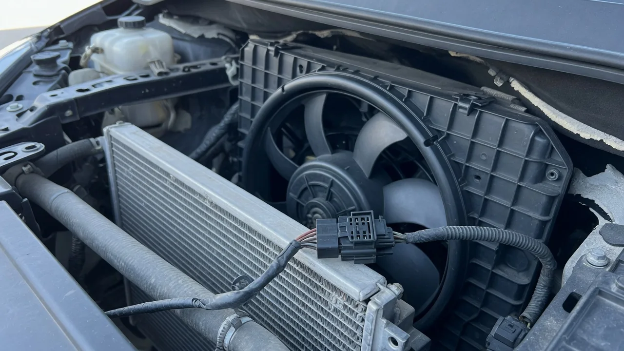 Automotive cooling fan assembly and electrical connector beside a radiator with the engine off