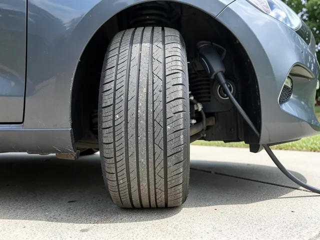 Close-up of an electric car tire showing tread grooves and shoulder wear during a parked inspection