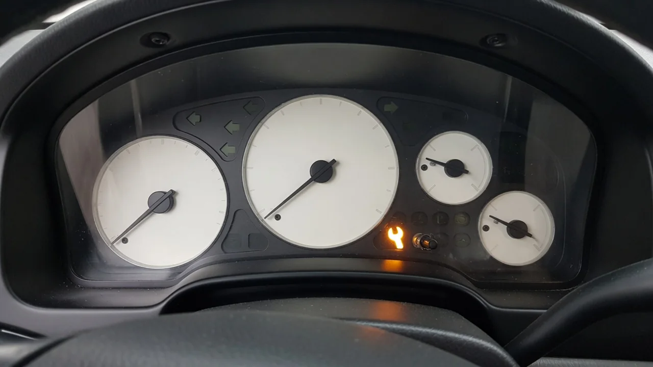 Illuminated amber wrench symbol on a generic vehicle instrument cluster