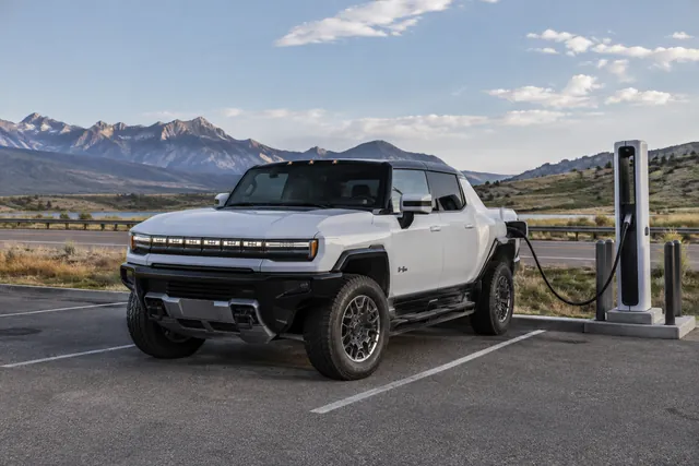 GMC Hummer EV pickup parked at a charging stop along an open highway