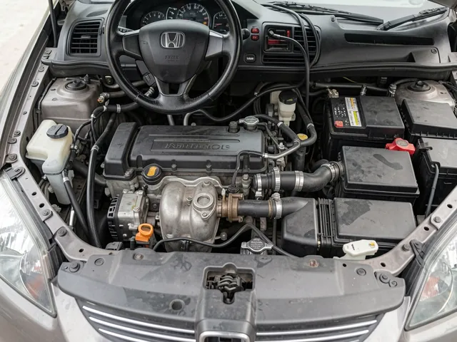 Honda Civic engine bay with a PCV valve and ventilation hose highlighted