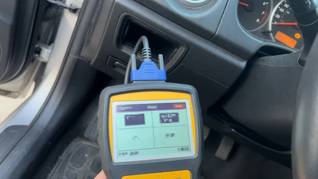 OBD-II scan tool connected under a car dashboard displaying a diagnostic trouble code