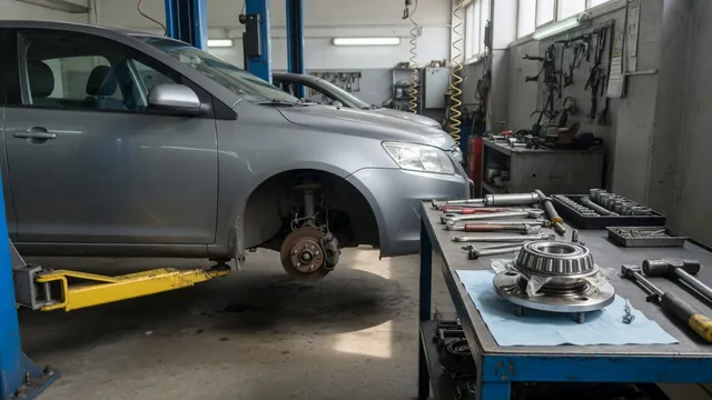 Toyota Tacoma wheel hub area with a bearing assembly on a nearby workshop bench
