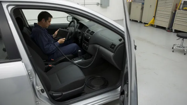 Diagnostic scanner connected beneath a vehicle dashboard while a technician reviews the results