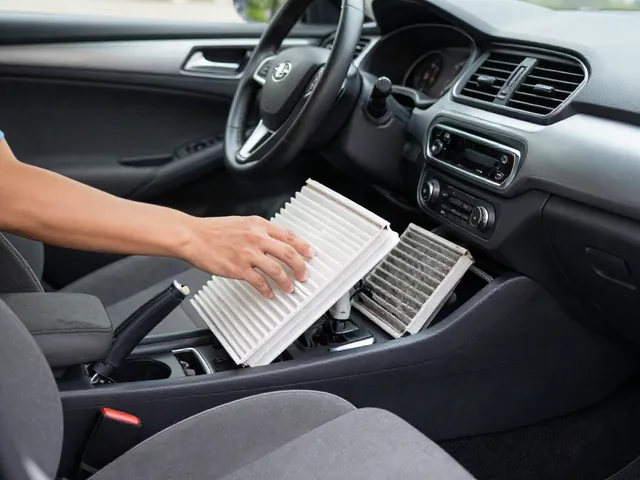 Hands installing a new cabin air filter into a car's glovebox housing with the old dirty filter beside it
