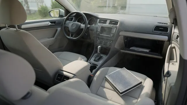 Car interior with faint haze near the dashboard air vents and a cabin air filter on the passenger seat