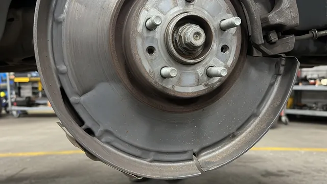 Close-up of a brake rotor and dust shield showing a bent edge near the rotor surface