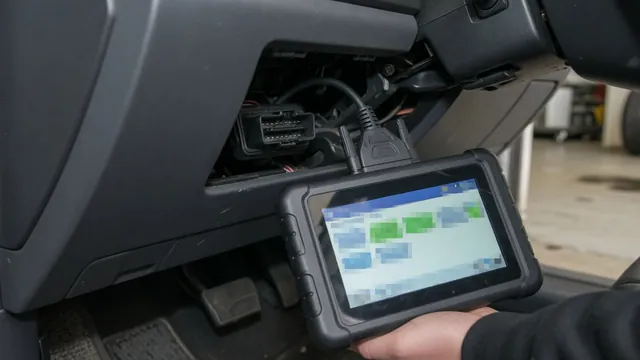 OBD-II scan tool connected under a car dashboard, showing a timing signal pulse waveform during diagnosis