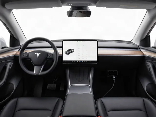 Tesla interior with a parked vehicle's touchscreen and steering wheel visible