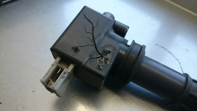Ignition coil with a cracked housing, dark arc track, and heat damage near its electrical connector