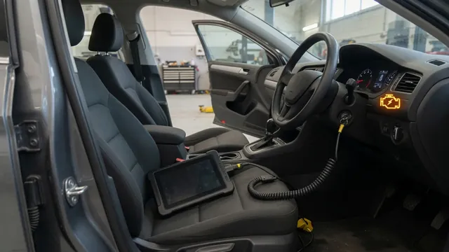 Diagnostic scanner connected inside a parked vehicle with an engine warning light illuminated