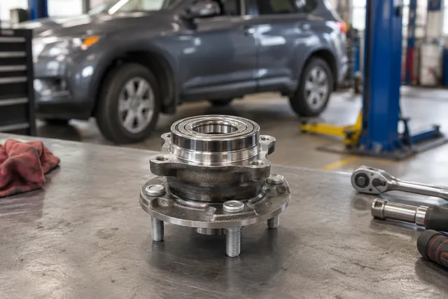 Wheel hub and bearing assembly on a workbench in an automotive repair shop