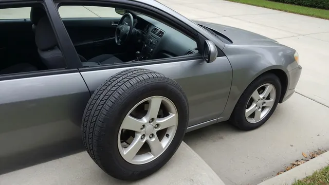Parked car with its front tire, wheel rim, and tread visible for inspection