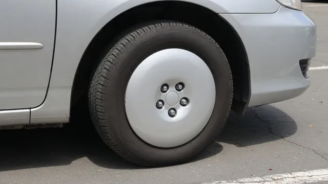 Front wheel and tire of a parked car with a visible hubcap and lug nut area