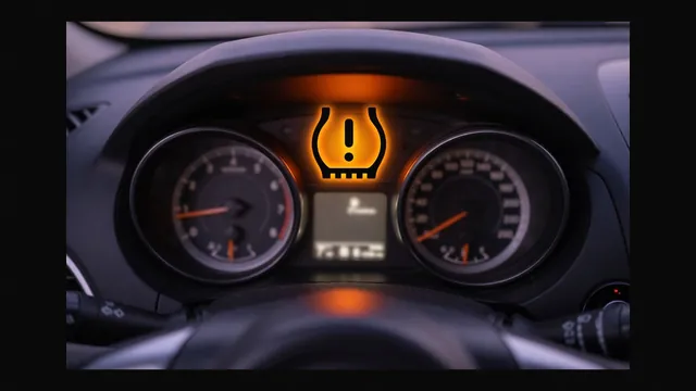 Amber TPMS warning light showing a tire cross-section with an exclamation mark lit up on a car dashboard