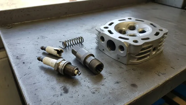 Broken spark plug, extractor tool, and thread repair insert arranged beside a cylinder head