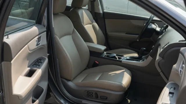 Vehicle interior showing door window controls, power seat switches, and a key fob on the center console