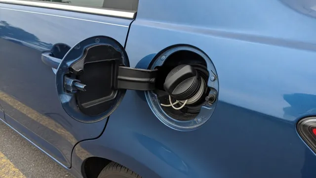 Fuel filler door open with a removable gas cap seated on the filler neck