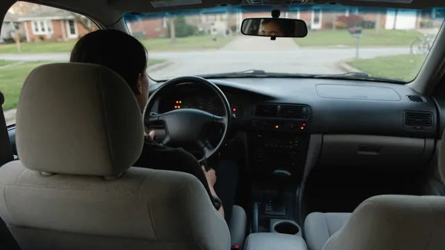 Driver seated in a parked car, observing dashboard lights during a starting problem