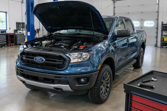 Ford Ranger engine bay with a flashlight and inspection mirror ready for an EGR valve inspection
