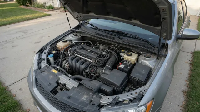 Open engine bay of a parked car with the engine and mounting area visible