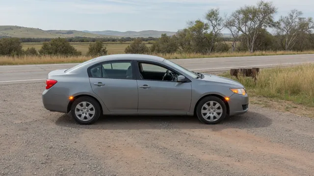 Car stopped in a roadside pullout with its hood closed and hazard lights flashing