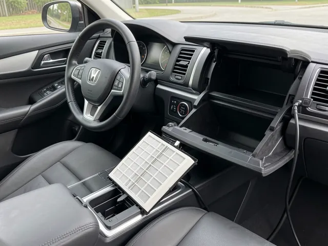 Cabin air filter beside an open glove compartment with the vehicle parked