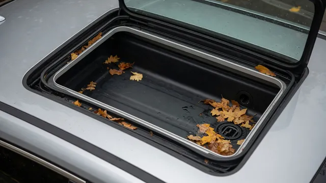 Open car sunroof showing a wet channel with leaves near a corner drain opening