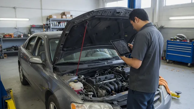 Technician reviewing diagnostic scan data beside a vehicle with its hood open