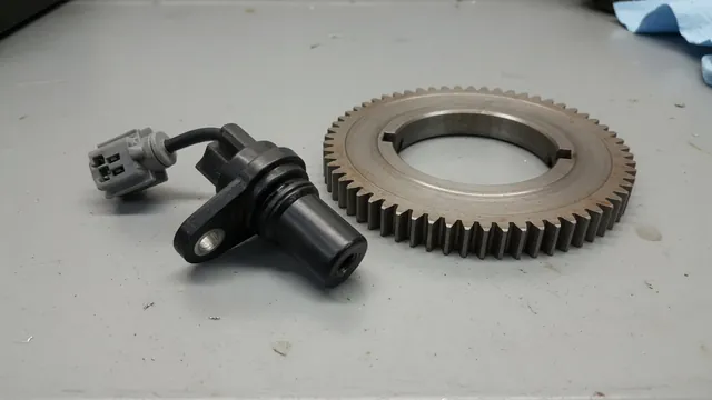 Illustration of a crankshaft position sensor near a crankshaft reluctor wheel with an electrical connector