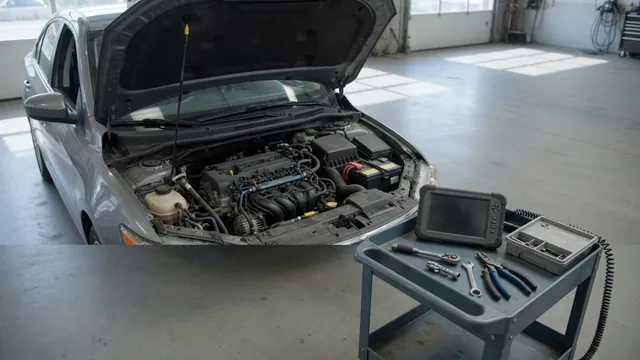 Diagnostic scanner beside a vehicle with its hood open in a service bay