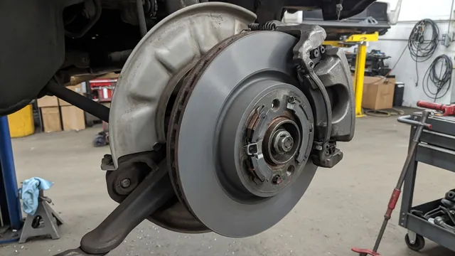 Brake rotor, dust shield, pads, and retaining hardware shown with the wheel removed