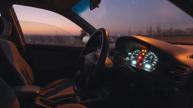Dashboard with several illuminated warning symbols and uneven instrument lighting inside a parked car