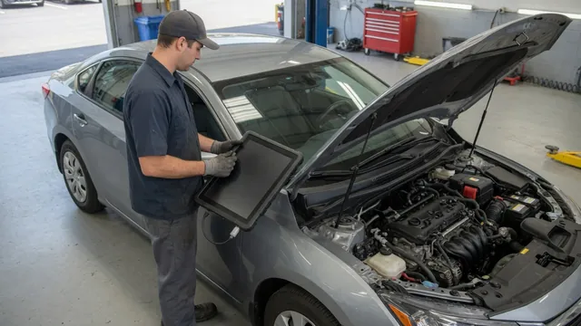 Technician reviewing diagnostic scan results beside a parked vehicle with its hood open