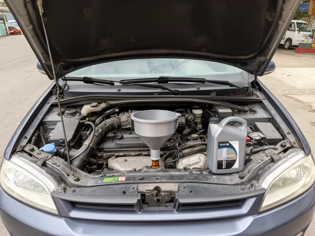Clean funnel positioned in an engine oil filler opening with the engine off