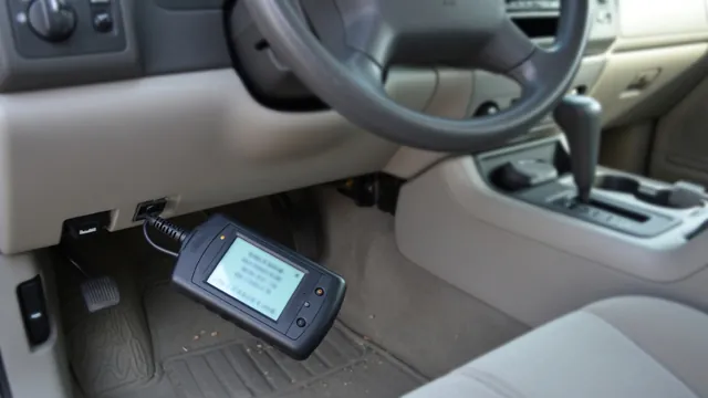 OBD-II scan tool plugged in under a car dashboard to read a stored engine trouble code