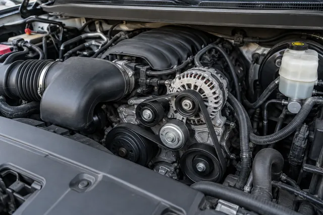 Engine-off view of a GM truck accessory belt, showing pulley grooves and the belt tensioner.