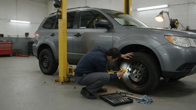 Ford Explorer parked in a service bay with a technician inspecting the front wheel area