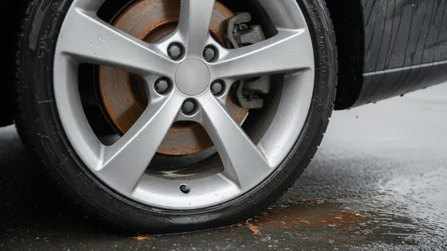 Light orange surface rust on a brake rotor visible through a parked car's wheel spokes