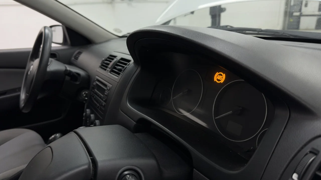 Illuminated amber ABS warning light on a car dashboard before a vehicle inspection
