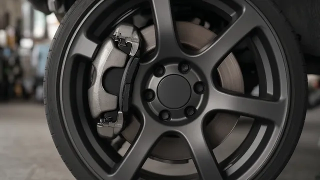 Front disc brake rotor and caliper seen through a car wheel, illustrating a car that shakes when braking