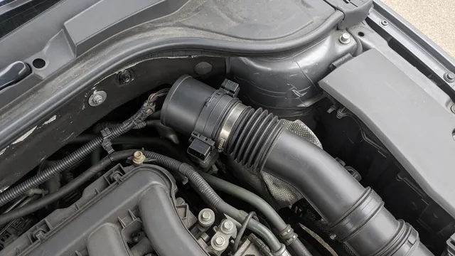 Illustration of an intake air sensor mounted in an air intake duct under a vehicle hood