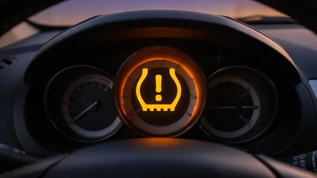 Amber tire pressure warning light illuminated on a car dashboard instrument cluster