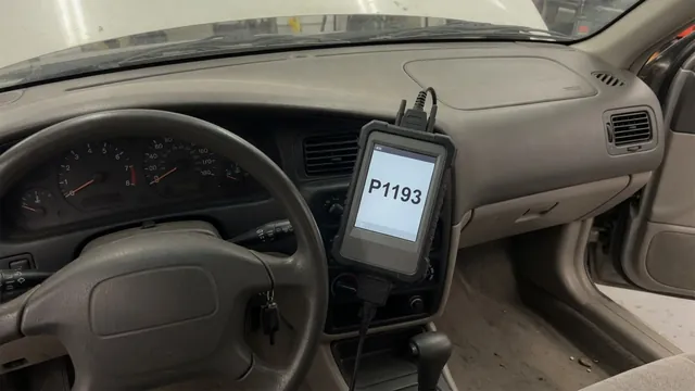 Diagnostic scanner displaying P1193 beside a vehicle dashboard