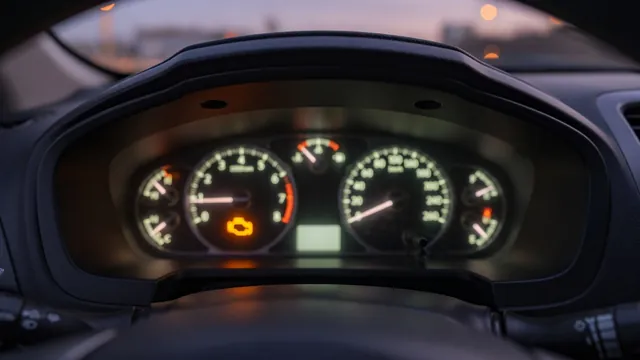 Amber check engine warning light illuminated on a car dashboard instrument cluster