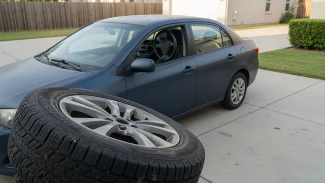 Car parked on a driveway with a close view of the tire tread and wheel