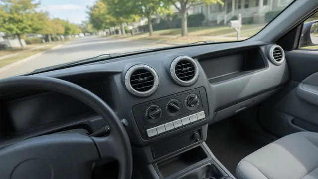 Car dashboard heater vents and climate controls with the vehicle parked outdoors