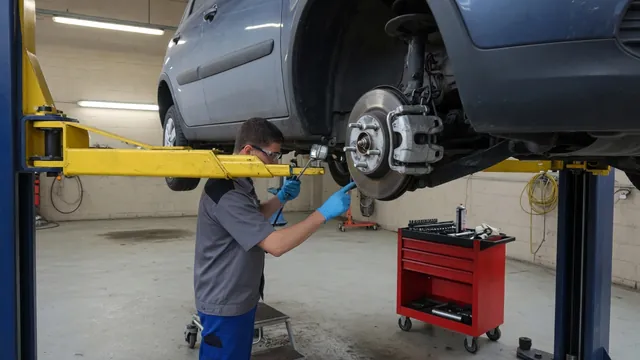 Technician inspecting a wheel hub on a securely supported vehicle in a repair shop